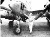 Large photo of Dick Bong looking at the nose art on his P-38 (72819 bytes)